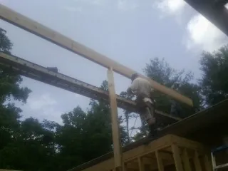 Carpenter setting a ridge beam over a new addition frame — Ice Dam Removal by Roofing Brothers in Rufe