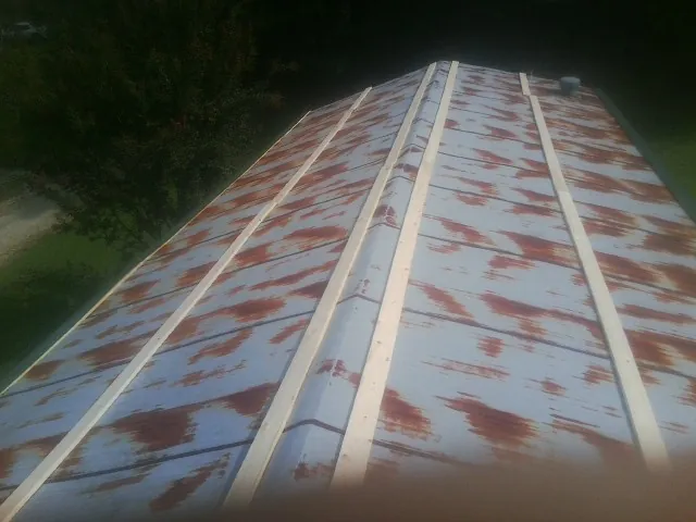 Rusted metal roof panels with new wood purlins before replacement — Storm Damage Roof Repair in Rufe by Roofing Brothers