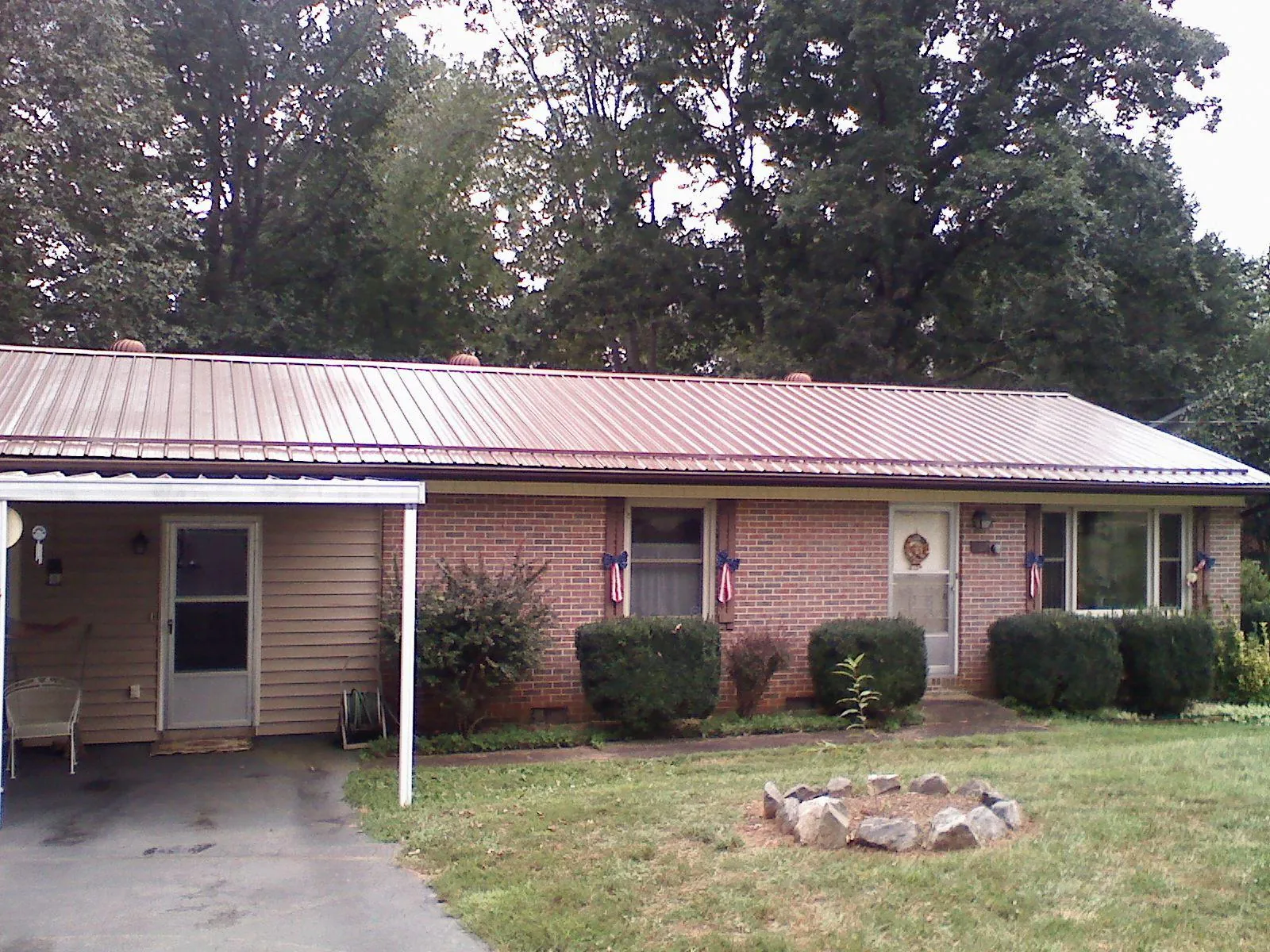Bronze metal roof and carport on a brick ranch home — Roof Repair work by our crew in Rufe